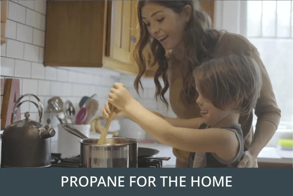 Adult and child cooking together on a gas stove under the heading Propane for the Home